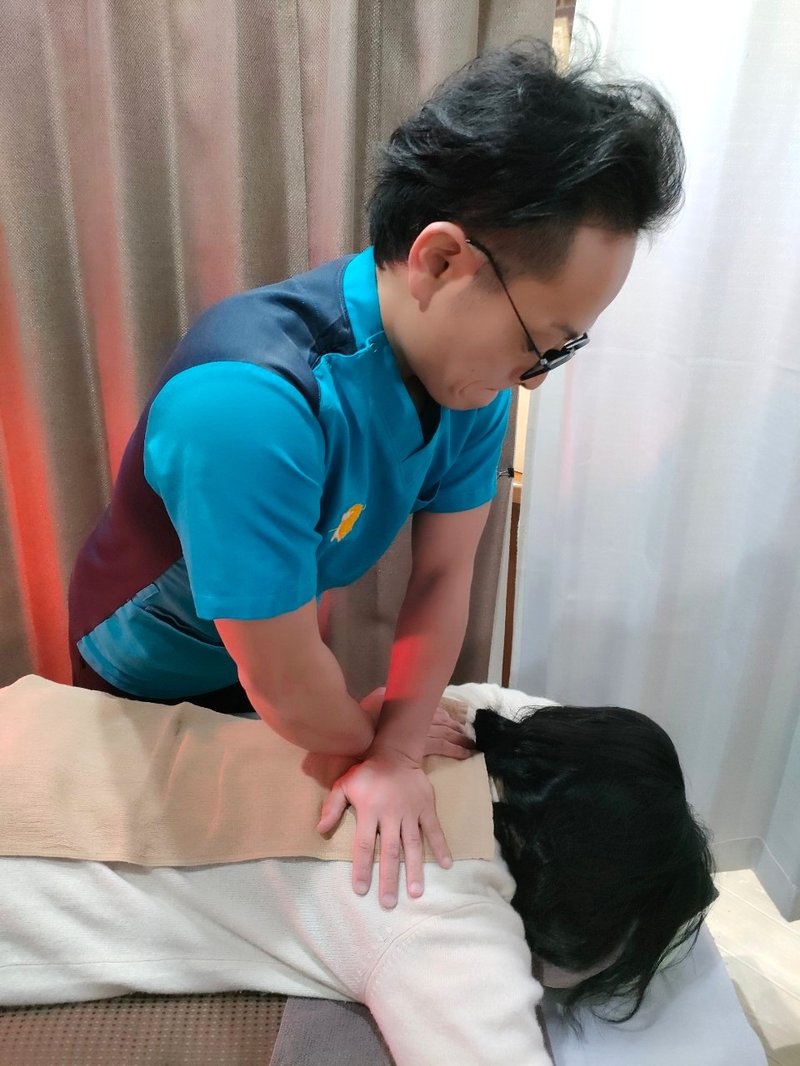 矢上真吾が、うつぶせの患者さんの背中を両手で真上から圧している指圧の写真